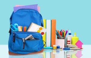 School Backpack with stationery on background